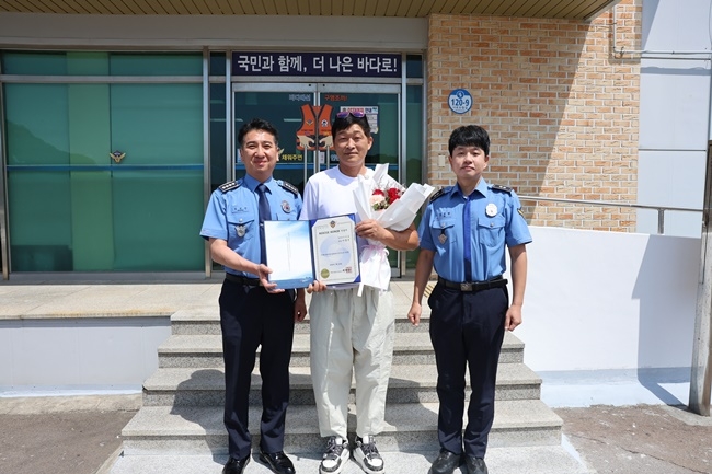 여수해경 명성민 서장(왼쪽)이 13일 어선 침수 사고 당시 승선원 구조에 기여한 이충식 씨(가운데)와 함께 기념 촬영하고 있다.