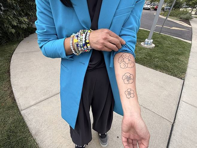 Wisconsin Representative Francesca Hong shows her tattoos of Mugunghwa, Korea's national flower, on Tuesday before the Democratic Party's gubernatorial primary results come out. (Yonhap)