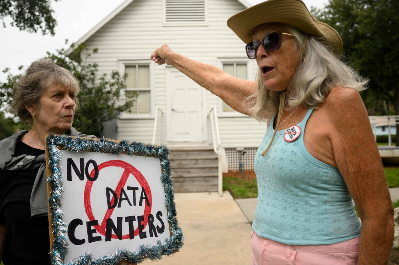 People hold signs during a protest against AI data center expansion in Florida on July 18, amid similar protests across the United States. (AFP)