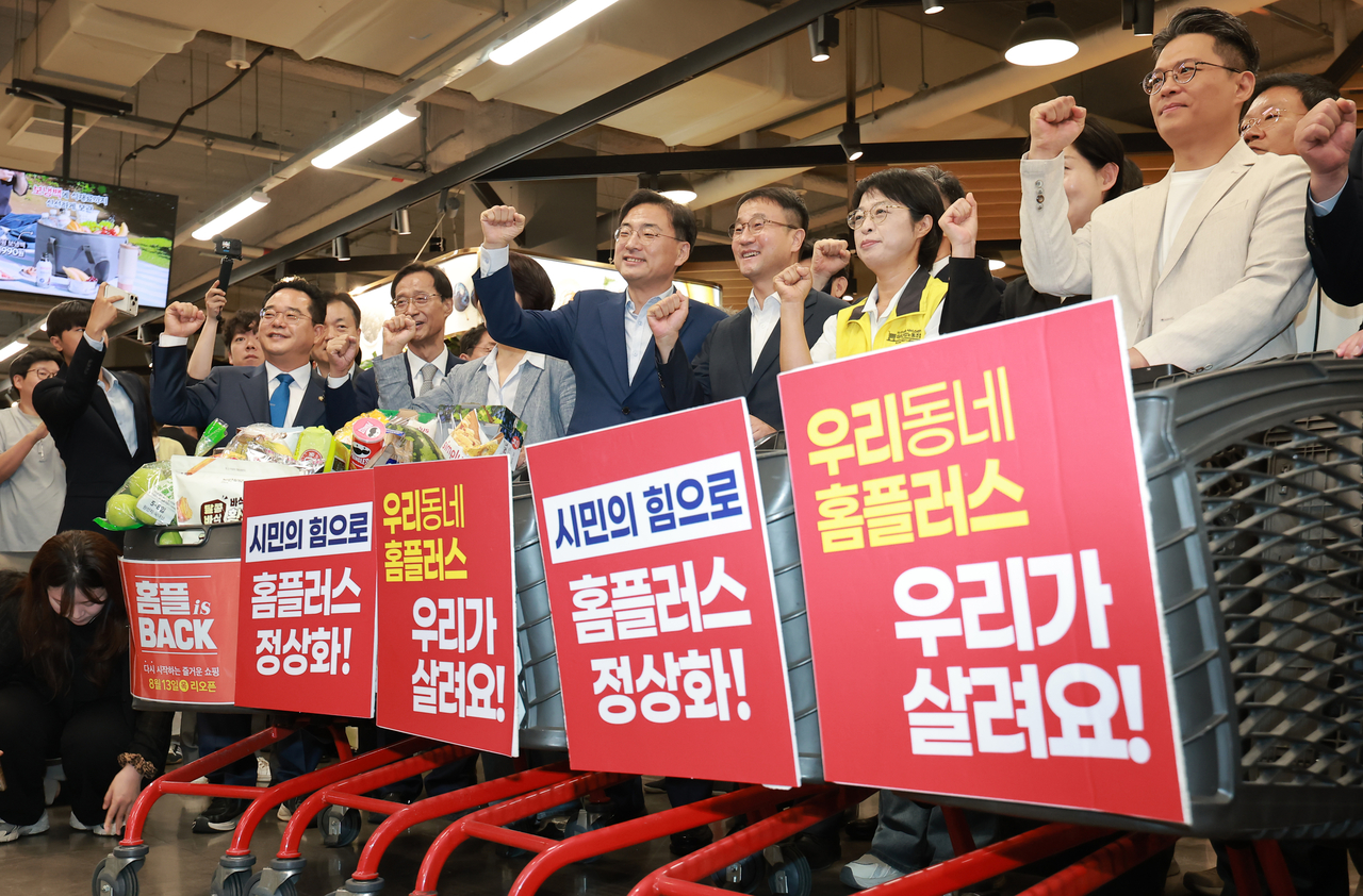 Politicians, including Han Byung-do, acting floor leader of the ruling Democratic Party of Korea, and Shin Jang-sik, leader of the minor Rebuilding Korea Party, hold a news conference at a Homeplus store in Seoul on Thursday, urging consumers to shop at the retailer to support its recovery. (Yonhap)