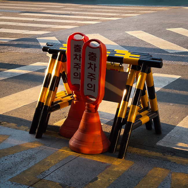 Safety posts warning pedestrians of vehicles exiting a parking garage (Courtesy of Max Adoubleyou)
