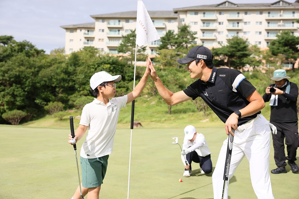 Park Jun-hong high-fives a young player at the camp