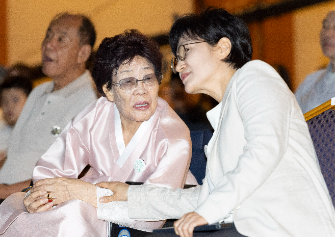 Lee Yong-soo (center), a survivor of Japan's wartime sexual slavery, speaks with the Minister of Gender Equality and Family Won Min-kyong at a memorial ceremony at the Kim Koo Museum & Library in Seoul on Friday. (Yoon Chang-bin/The Korea Herald)