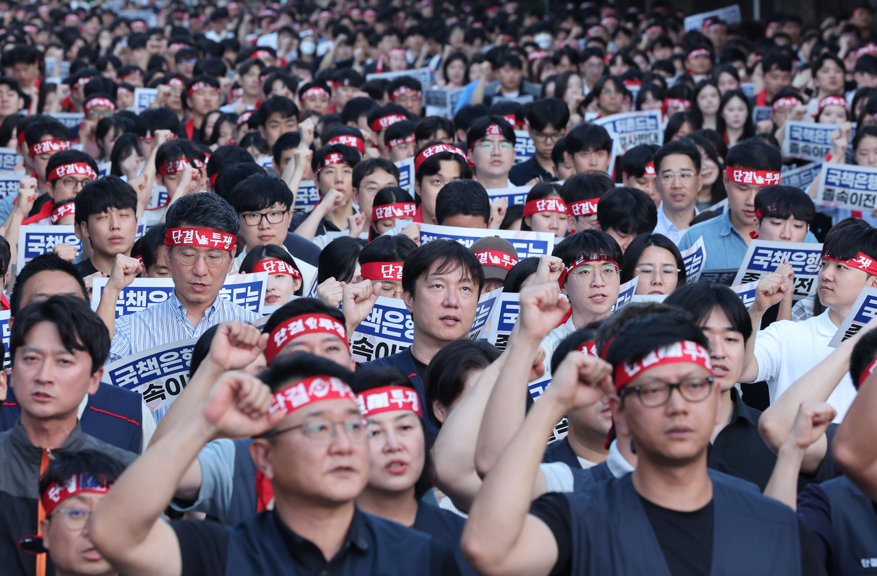 Members of the unions at Korea Development Bank, Industrial Bank of Korea and Export-Import Bank of Korea chant slogans during a joint rally against regional relocation plans in front of Korea Development Bank's headquarters in Yeouido, Seoul, on Tuesday. [Yonhap]