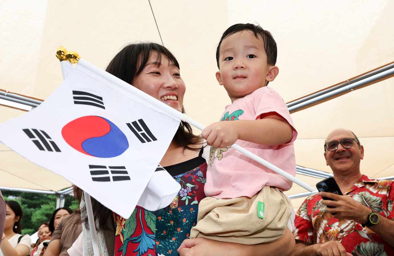 A child shakes the Korean national flag during a bell-ringing ceremony marking the 81st anniversary of Korea’s Liberation Day at Bosingak Pavilion in central Seoul on Saturday. (Yonhap)
