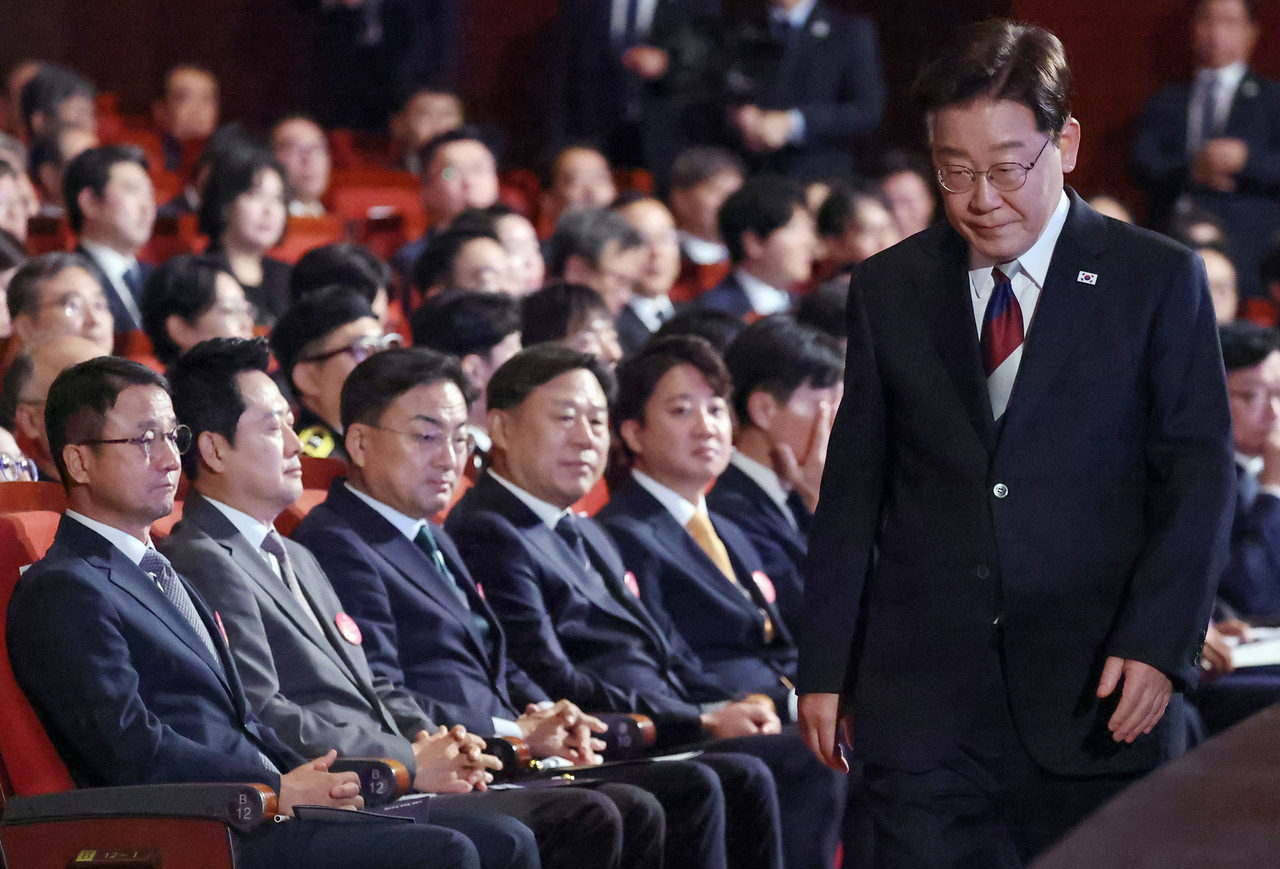 President Lee Jae Myung returns to his seat after delivering a congratulatory address at the 81st Liberation Day ceremony at the Sejong Center for the Performing Arts in Jongno-gu, Seoul, on Saturday. Behind him, from left, are Democratic Party of Korea acting leader Han Byung-do, People Power Party leader Jang Dong-hyeok, Rebuilding Korea Party leader Shin Jang-sik, Progressive Party leader Kim Jong-hun and Reform Party leader Lee Jun-seok. [Yonhap]