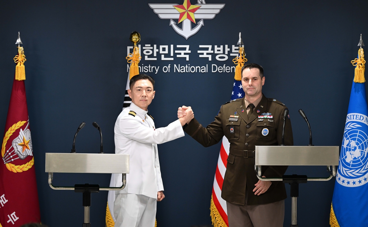 South Korea's Joint Chiefs of Staff Cpt. Jang Do-young (L) shakes hands with US Forces Korea Col. Ryan Donald during a joint press briefing on the Freedom Shield 2026 combined exercise at the Ministry of National Defense in Seoul on Aug. 10. (Pool photo via Yonhap)