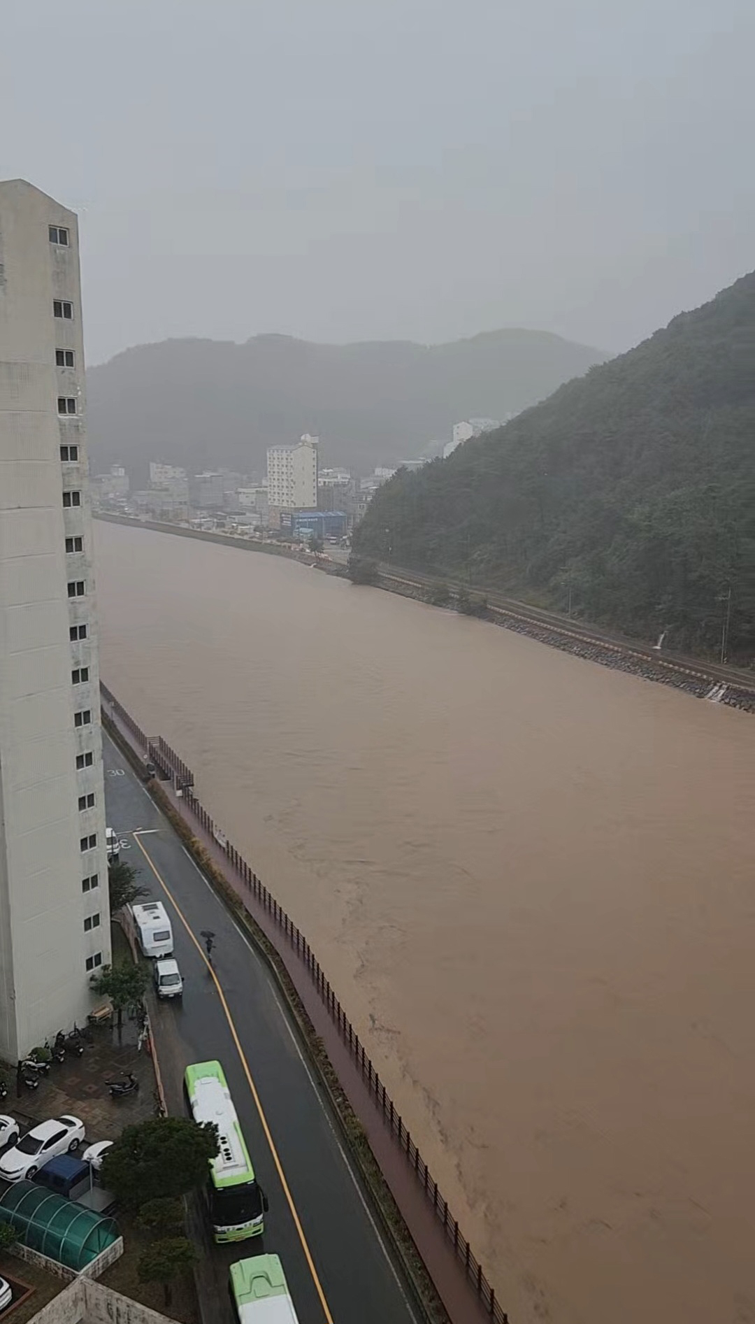 A stream swells near an apartment complex in Geoje, South Gyeongsang Province, following heavy rain on Monday. (Yonhap)