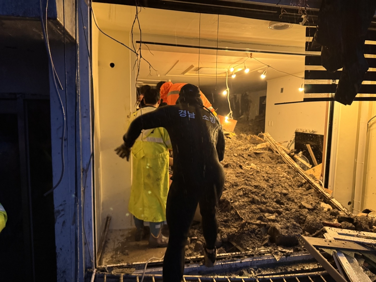 Firefighters conduct a rescue operation following a landslide in a residential area in Geoje, South Gyeongsang Province, on Monday morning. (Yonhap)