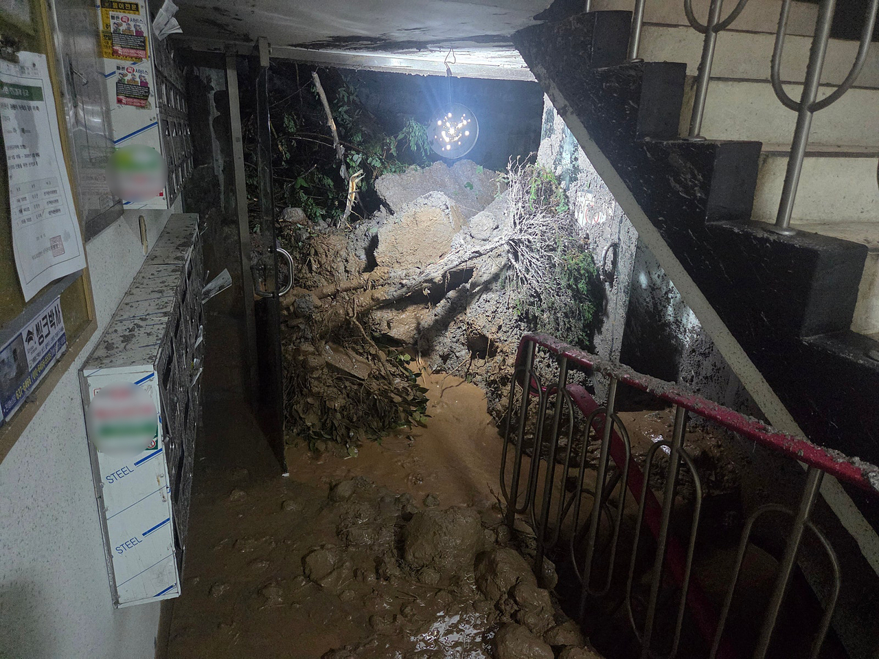 Debris from a landslide blocks the entrance to an apartment building in Geoje, South Gyeongsang Province, on Monday, as nearly 800 millimeters of rain fell in the area over three days. (Yonhap)