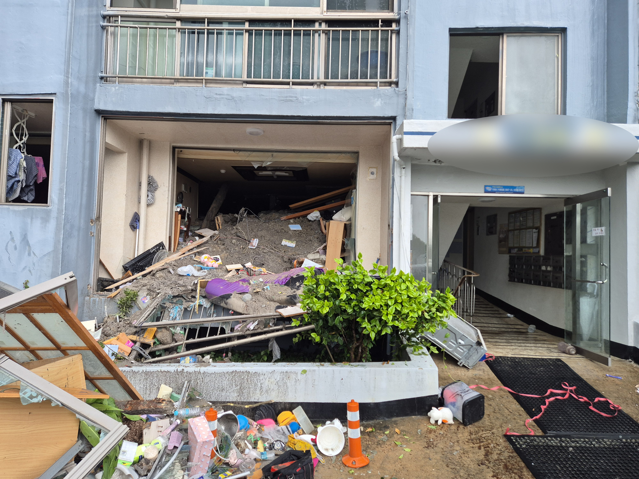 This photo shows a first-floor unit damaged after mud from a landslide swept into an apartment building in Okpo-dong, Geoje, South Gyeongsang Province, Monday. (Yonhap)