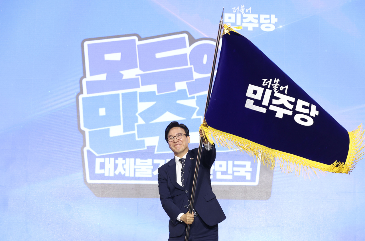 더불어민주당 김민석 신임 당 대표가 17일 대전 컨벤션센터에서 열린 제3회 더불어민주당 정기 전국당원대회에서 당 대표로 선출된 뒤 당기를 흔들어 보이고 있다. 2026.8.17 [공동취재] [연합]