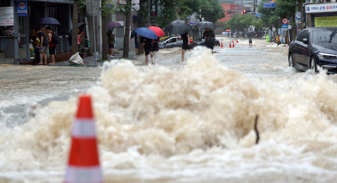 A road is flooded on Monday, in the southeastern city of Geoje, where a landslide triggered by heavy rain struck an apartment building the same day, killing one person and injuring two others. (Yonhap)