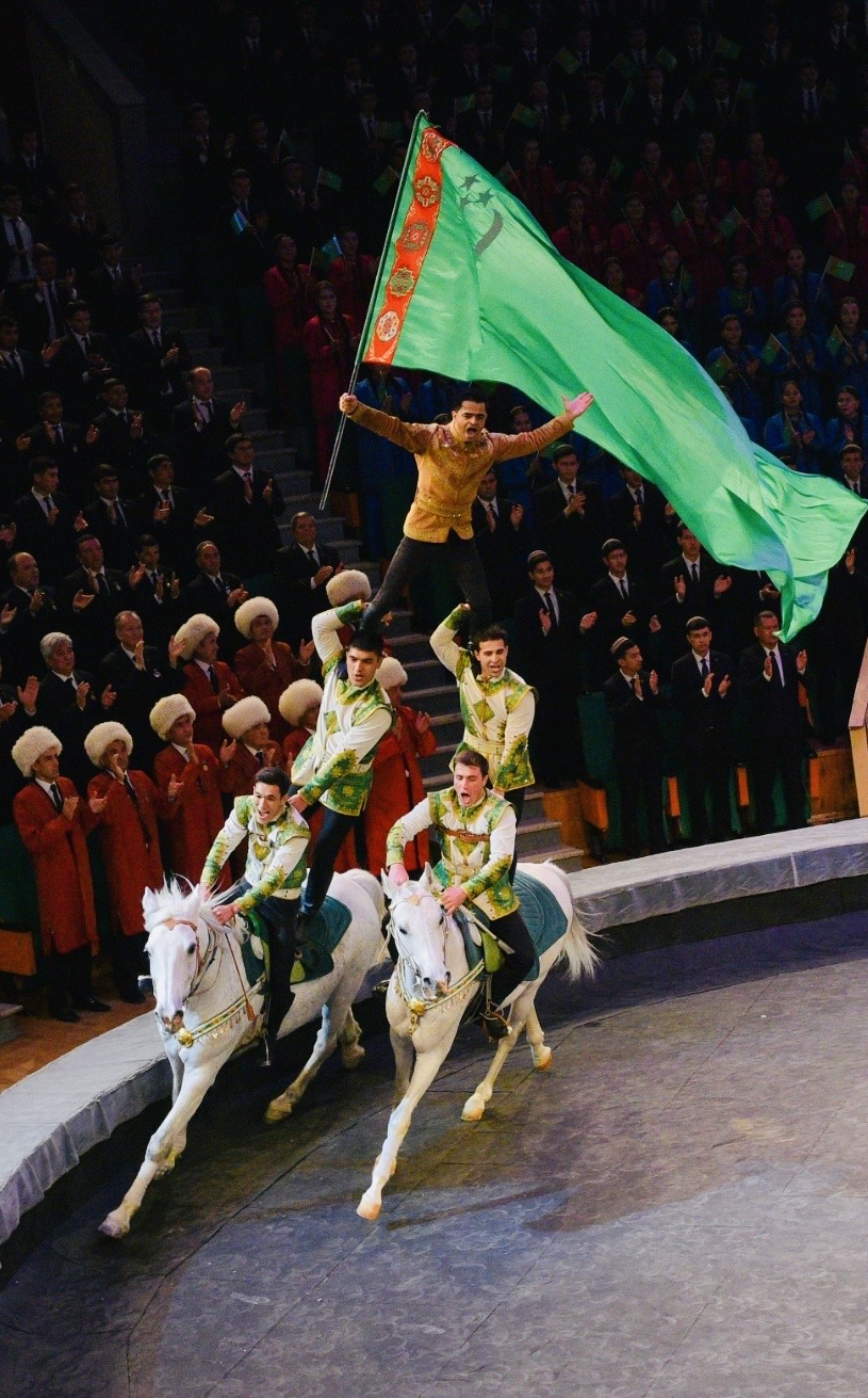 Turkmen equestrian performers showcase their horsemanship on Akhal-Teke horses as a rider waves a large Turkmenistan flag during a performance. (Embassy of Turkmenistan in Seoul)