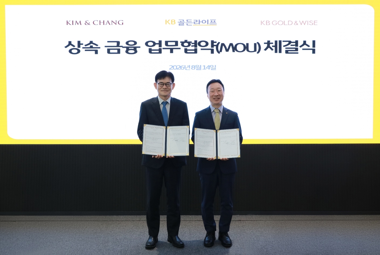 Lee Yun-seok (right), executive managing director of KB Kookmin Bank's WM Promotion Division, and Kim Yong-dae, head of the Family Affairs, Inheritance and Business Succession Center at Kim & Chang, pose for a photo at the MOU signing ceremony held at the KB Kookmin Bank annex in Yeouido, Seoul, on Friday. [KB Kookmin Bank]
