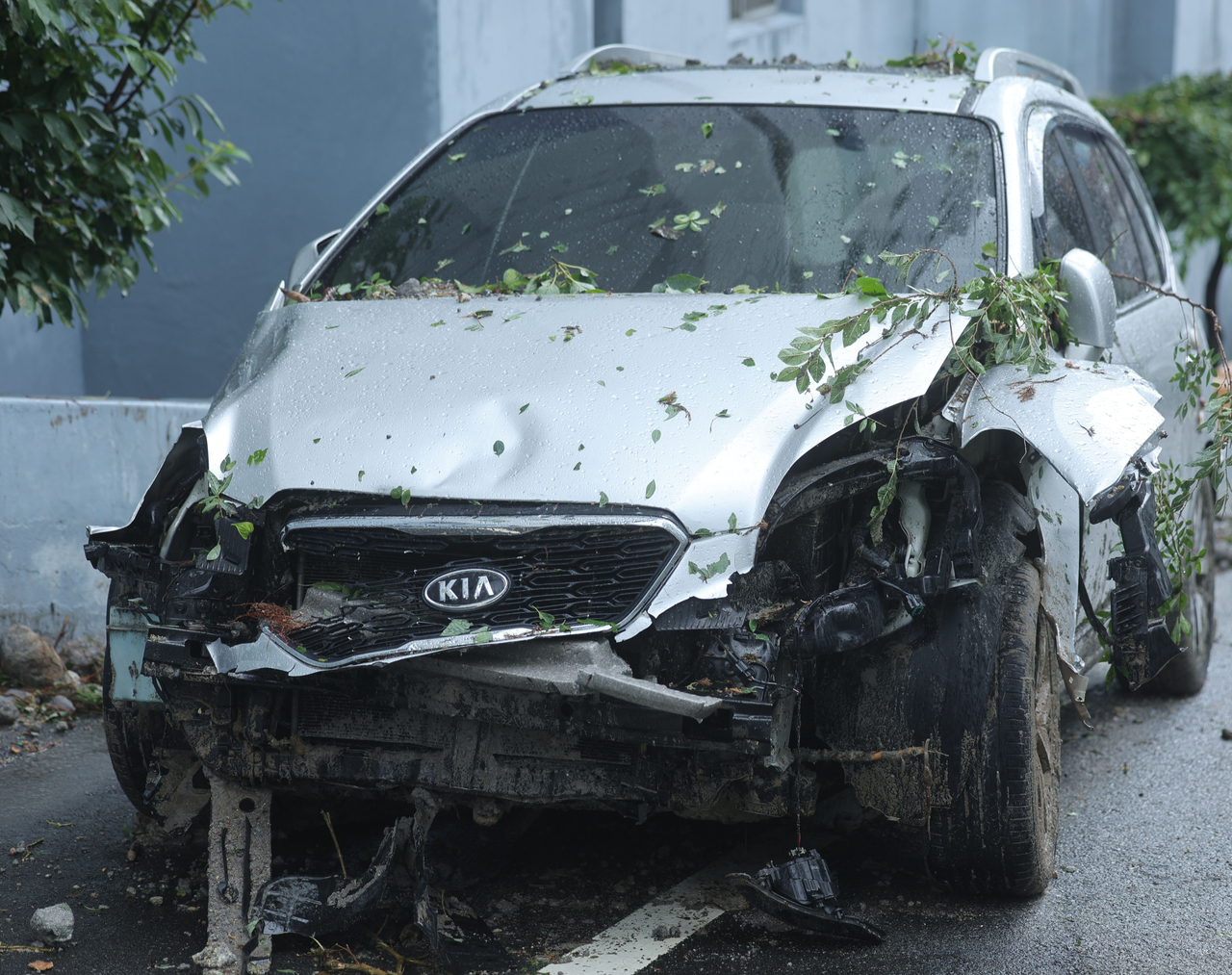 A damaged car is seen at an apartment complex in Okpo-dong, Geoje, South Gyeongsang Province, on Tuesday, as rain continues to hamper recovery efforts following a landslide the previous day. (Yonhap)