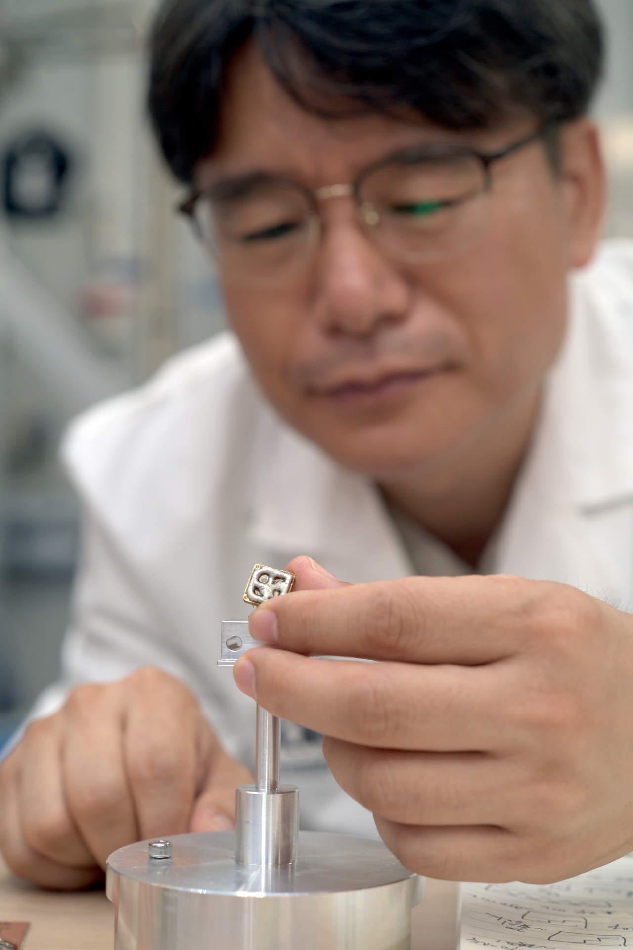Researchers at the Korea Research Institute of Standards and Science (KRISS) examine experimental components used to measure quantum transport in topological insulator nanowires. [KRISS]