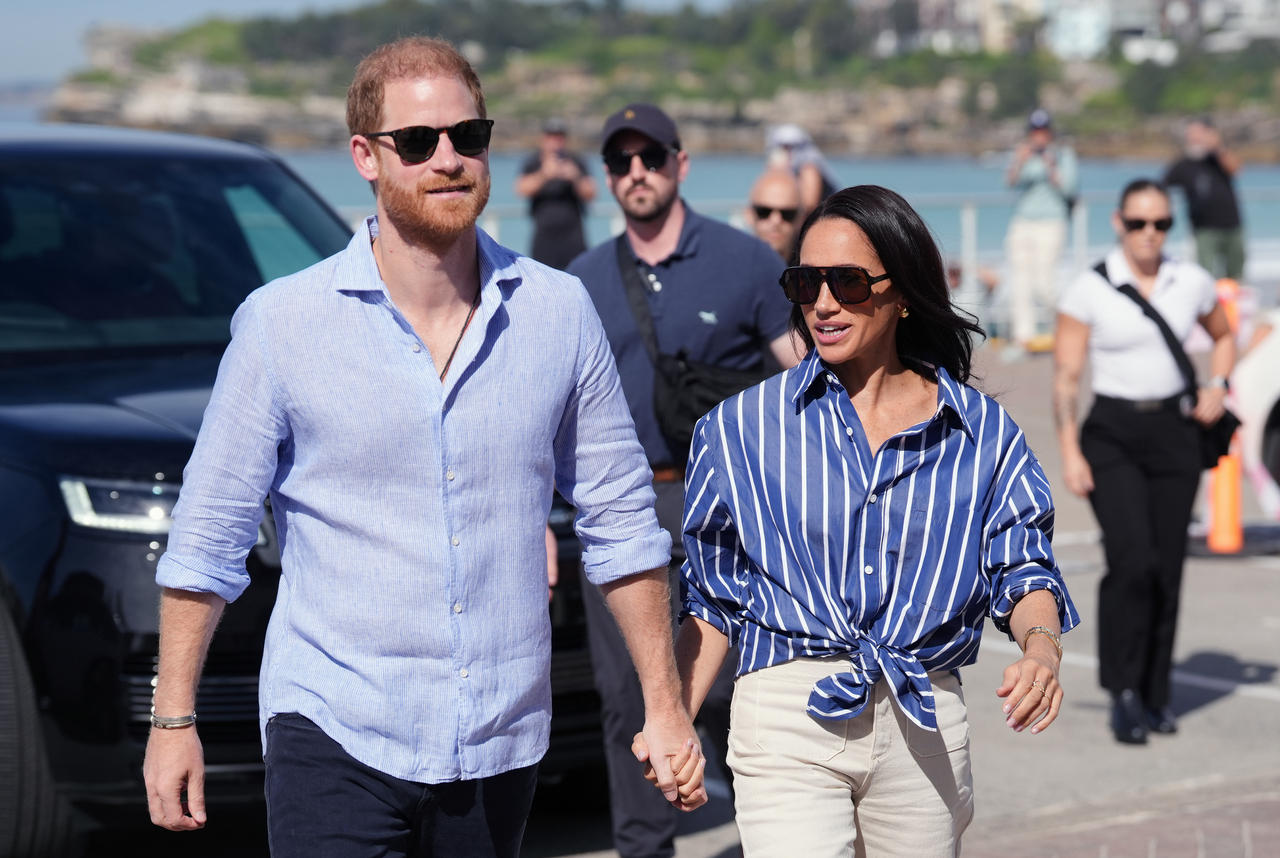 Prince Harry (left) and Meghan, the Duke and Duchess of Sussex, arrive for an event, during a visit to Bondi Beach, Australia, April 17.   AP-Yonhap