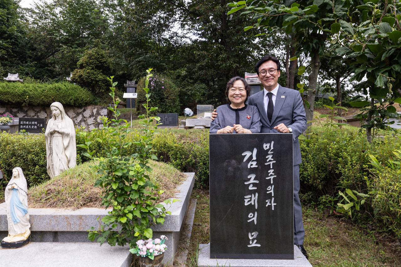 김민석 더불어민주당 대표는 20일 당에 ‘법치 파괴 조희대는 물러나야 한다’는 문구를 담은 현수막을 전국에 걸도록 지시했다. 김 대표가 이날 경기 남양주시 모란공원에 위치한 김근태 전 민주당 상임고문 묘역을 참배한 뒤 김 전 고문의 배우자인 인재근 전 의원과 사진을 찍고 있다. [연합]
