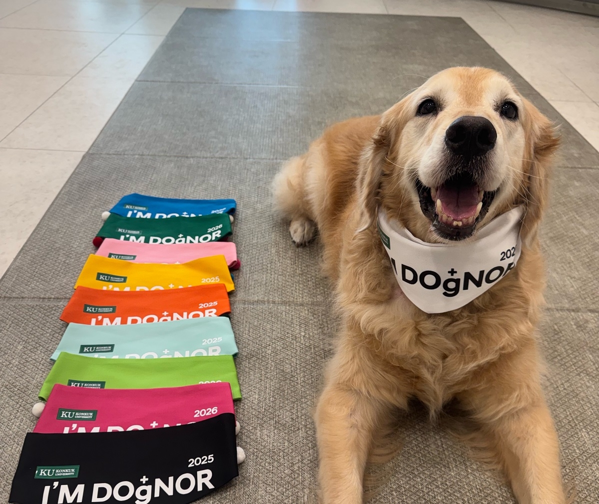 Cappu sits wearing a scarf marking his 10th blood donation after giving blood at Konkuk University’s KU I’m Dognor Blood Donation Center in Seoul, on the same day. Below are the different-colored scarves given to canine blood donors based on the number of donations they have made, ranging from blue for the first donation at the top to black for the ninth at the bottom. (Cappu’s owner)