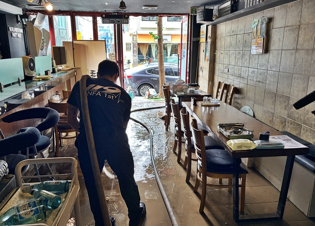 A firefighter pumps water from a restaurant in Geoje, South Gyeongsang Province, Tuesday. (Yonhap)