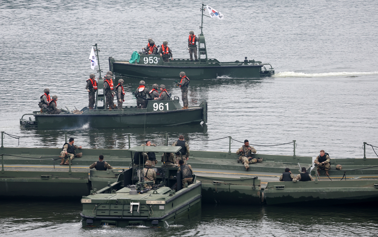 US troops rest on the pontoon bridge in the foreground while South Korean troops travel by boat in the background during a river-crossing exercise on the Imjin River on Friday. (Newsis)