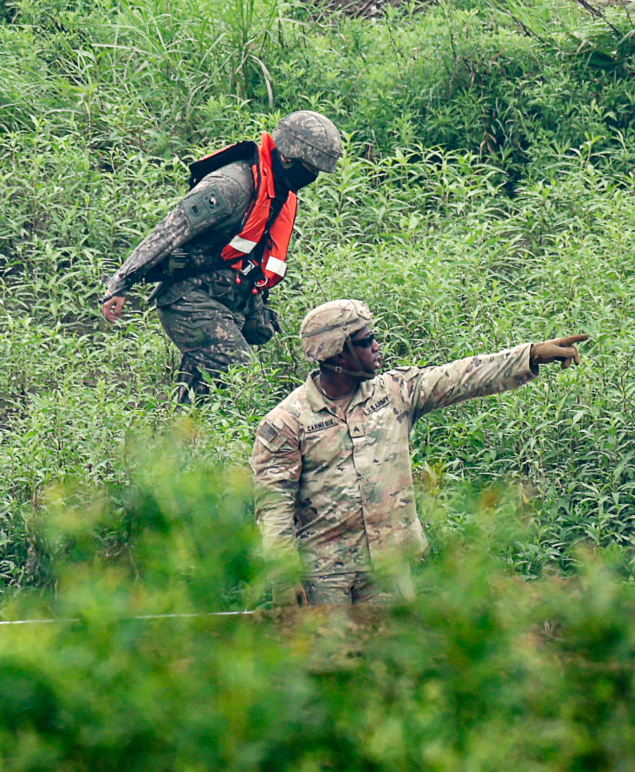 A US soldier and a South Korean soldier walk through a field during the Ulchi Freedom Shield exercise on Friday. (Newsis)