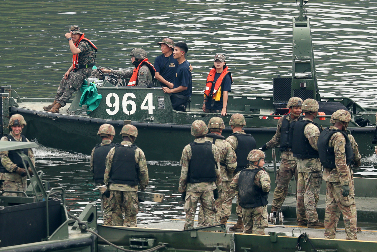 A South Korean soldier gives a thumbs up to US troops on the pontoon bridge while passing by on a boat with fellow soldiers during the Ulchi Freedom Shield exercise on Friday. (Newsis)