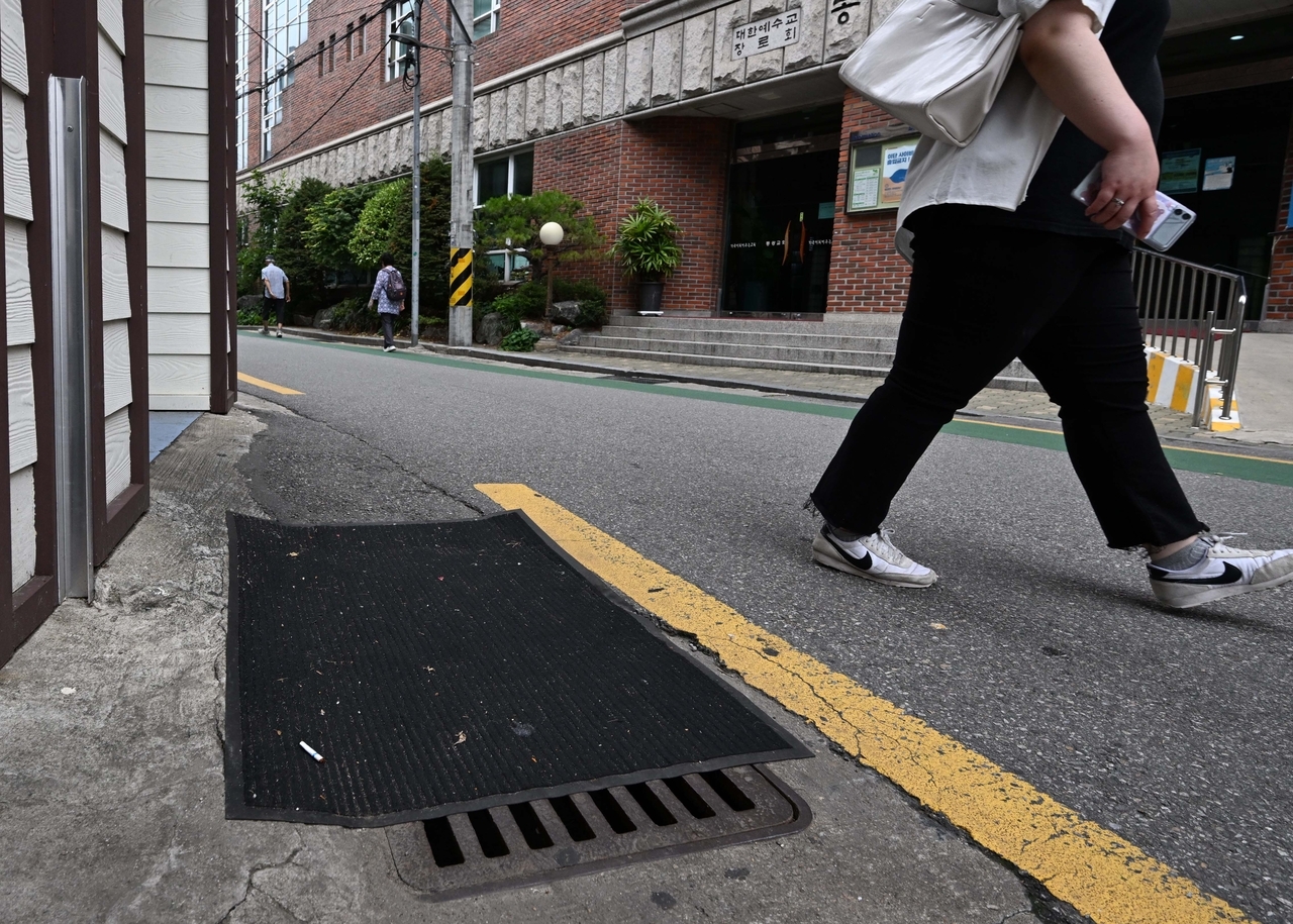 A mat covers a storm drain in Dongjak-gu, southern Seoul. Covers are often left on drains to block sewer odors or prevent illegal dumping. (Lee Sang-sub / The Korea Herald)