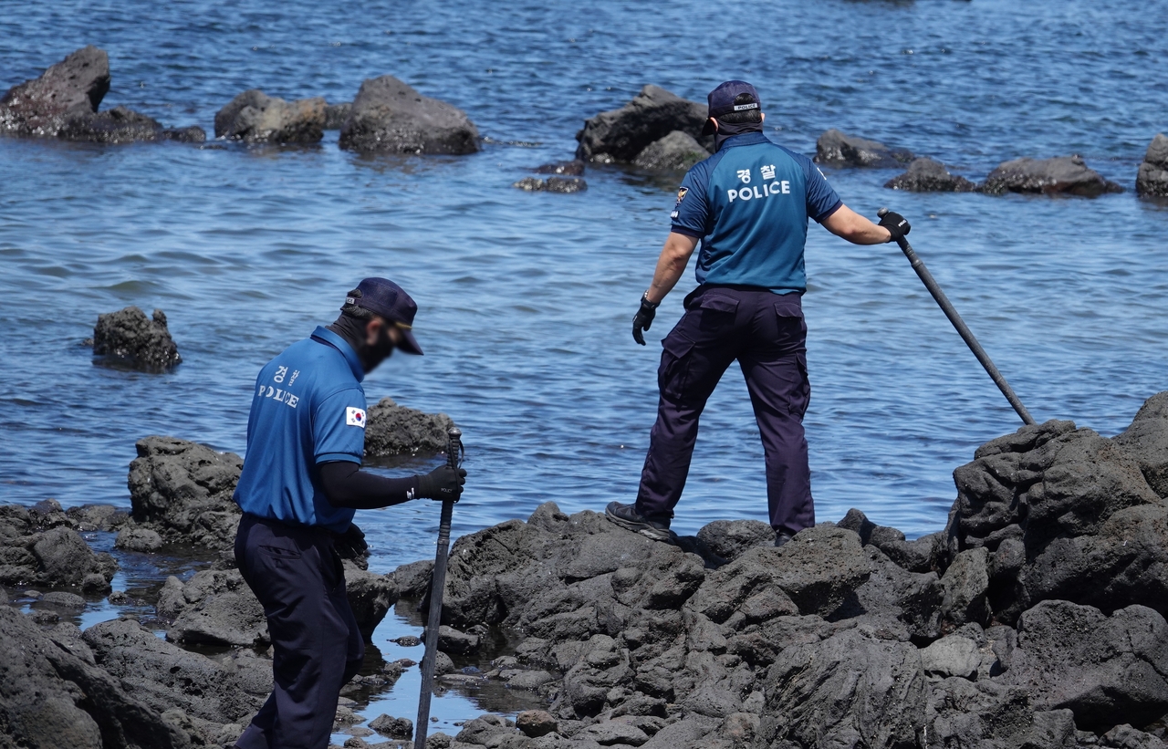 Police officers search for Jang Mi-ran on Wednesday at a beach in Hallim-eup, Jeju, after she went missing in May. (Newsis)