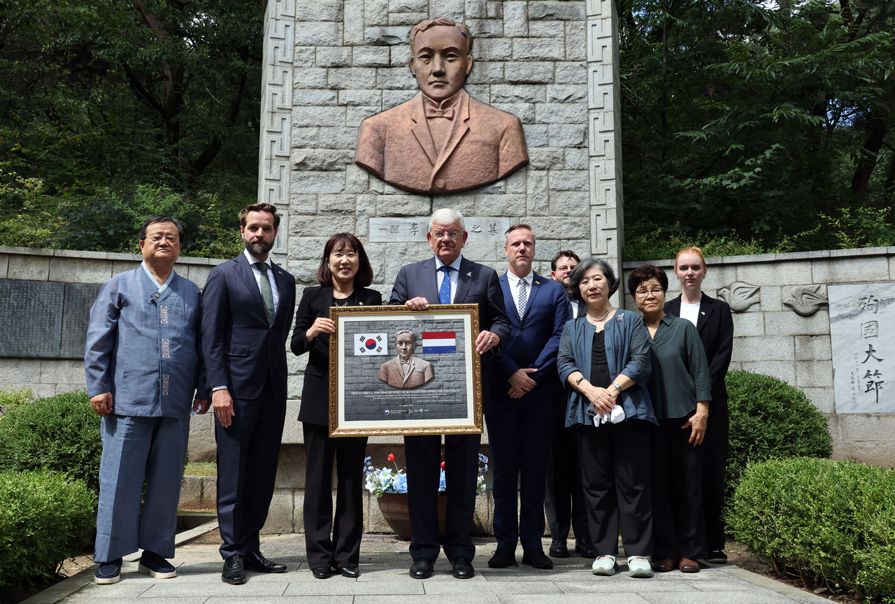 Kang Yunjin (third from left), vice minister of patriots and veterans affairs, and officials pose along Jan van Zanen (fourth from left), mayor of The Hague, Netherlands, in front of the tomb of Korean independence activist Yi Jun, in Seoul on Sunday. (Yonhap)