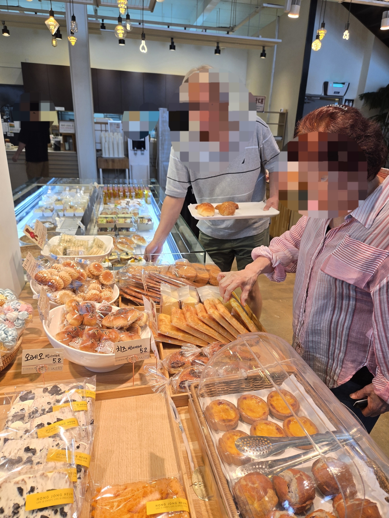 Two visitors choose pastries at a bakery cafe in Hanam, Gyeonggi Province, on Monday morning. (Choi Jae-hee / The Korea Herald)