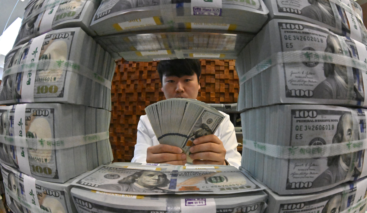 A staff member examines dollar bills at Hana Bank's counterfeit-detection center in Jung-gu, Seoul. (Lim Se-jun)