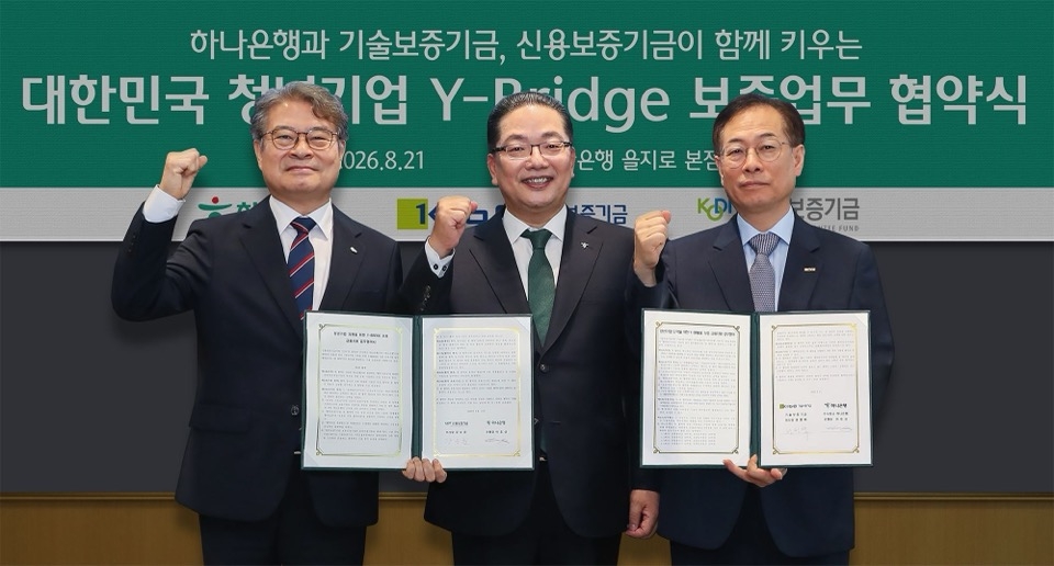 21일 서울시 중구 하나은행 을지로 본점에서 개최된 협약식에서 이호성 하나은행장(사진 가운데)이 권형택 기술보증기금 이사장(사진 오른쪽), 강승준 신용보증기금 이사장(사진 왼쪽)과 함께 협약서를 들고 기념촬영을 하고 있다.[하나은행 제공]