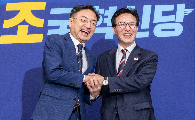 Democratic Party Chair Rep. Kim Min-seok (right) shakes hands with Rebuilding Korea Party Chair Rep. Shin Chang-sik at the National Assembly on Monday. (Yonhap)