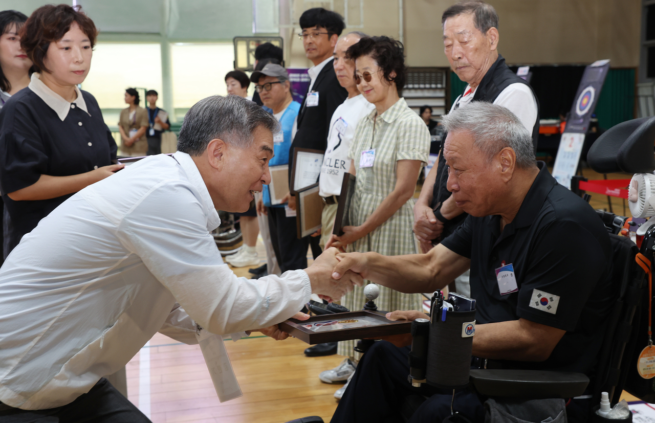 김현기 강남구청장(왼쪽)이 수상한 장애인 선수를 축하하고 있다.