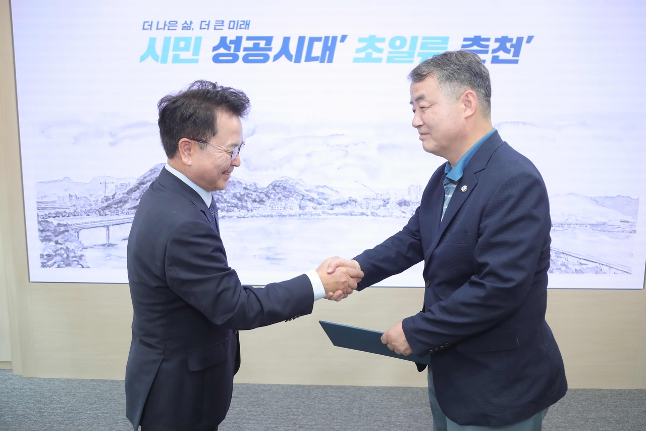 춘천문화재단 박종훈 이사장(오른쪽)이 24일 육동한 시장으로부터 임명장을 받은 뒤 악수하고 있다.