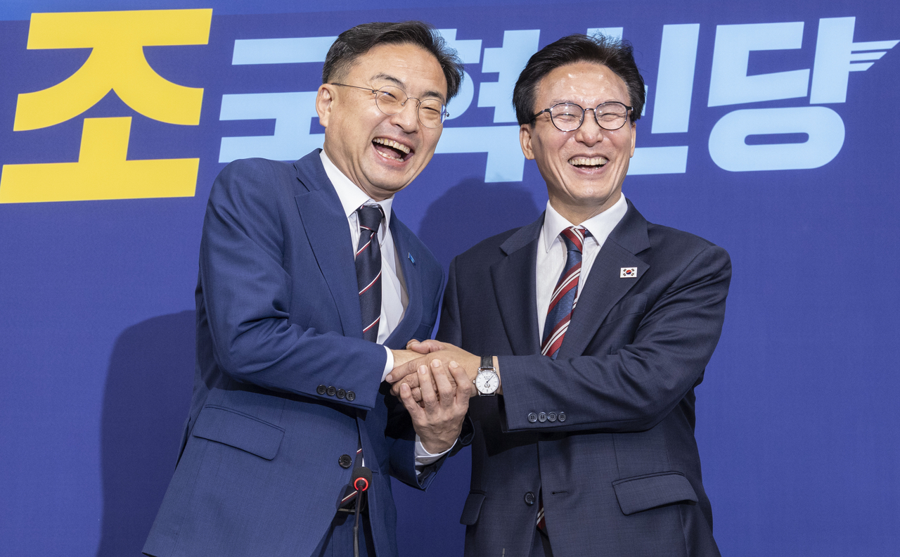 Democratic Party chair Rep. Kim Min-seok (right) shakes hands with Rebuilding Korea Party chair Rep. Shin Chang-sik in the National Assembly Monday. (Yonhap)