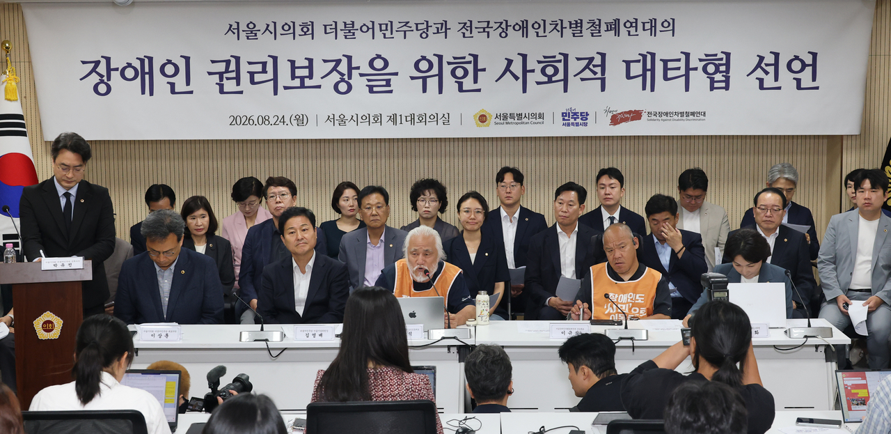 Democratic Party of Korea members of the Seoul Metropolitan Council and leaders of Solidarity Against Disability Discrimination speak during a news conference marking their agreement Monday, in central Seoul. (Yonhap)
