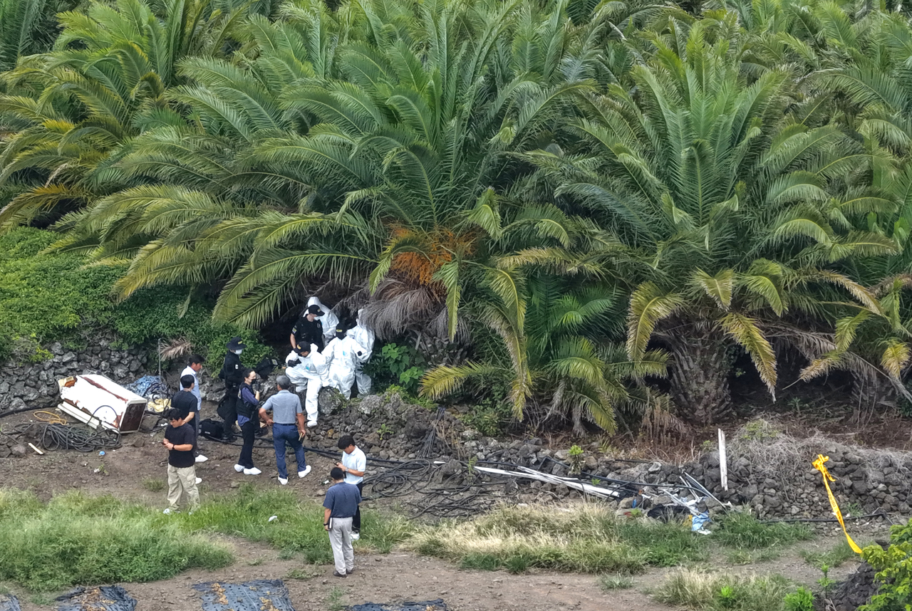 Police officers are seen at the site where a body believed to be that of missing woman Jang Mi-ran was discovered in Jeju on Monday. (Yonhap)