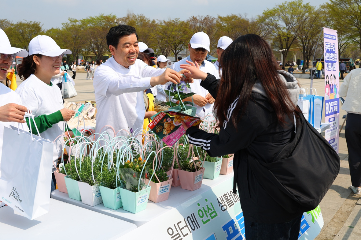 Park Jong-gil (center), president of the Korea Workers' Compensation and Welfare Service, and agency employees hand out mini flower pots and seed kits to citizens at Han River Park in Yeouido, Seoul, on Arbor Day, April 5, 2025. [Korea Workers' Compensation and Welfare Service]