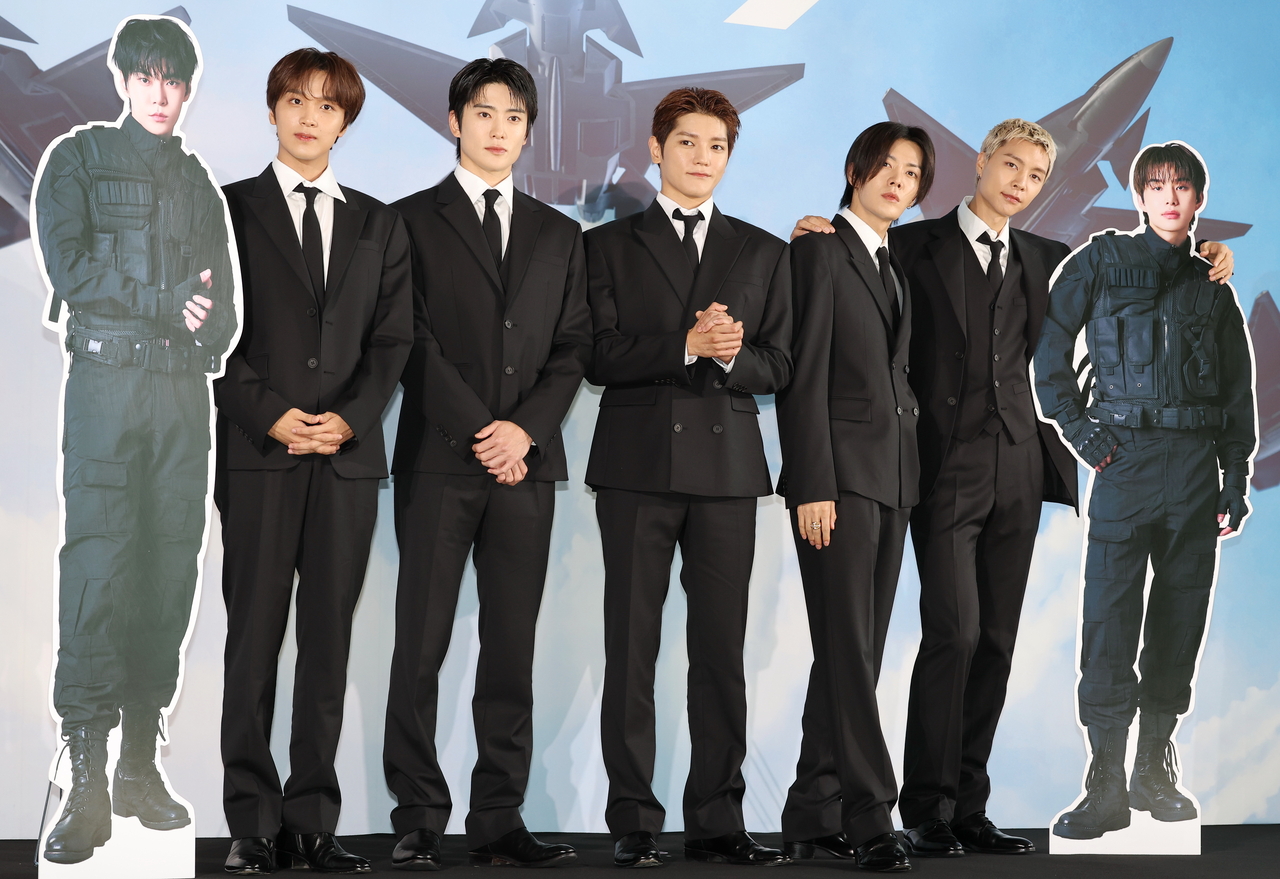 NCT 127 poses with cardboard cutouts of members Doyoung (left) and Jungwoo, during a press conference held ahead of the release of "Blingy" at Lotte Tower in southern Seoul on Monday. (Yonhap)