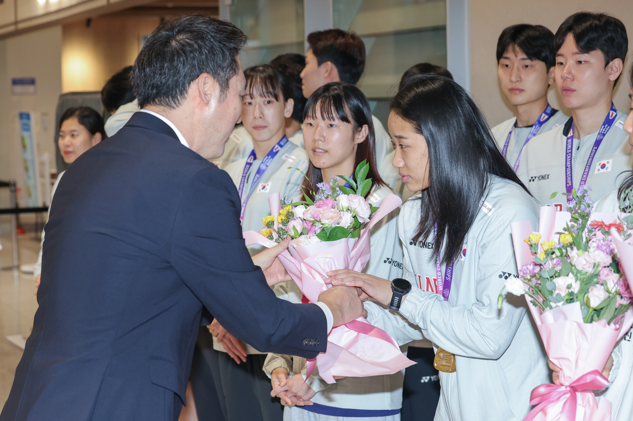 An Se-young receives a bouquet from Kim Dong-moon, president of the Badminton Korea Association, at Incheon Airport on Tuesday.