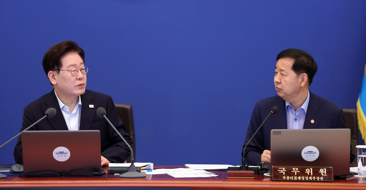 President Lee Jae Myung speaks with Deputy Prime Minister and Minister of Economy and Finance Koo Yun-cheol at a Cabinet meeting held at Cheong Wa Dae on Tuesday. [Yonhap]