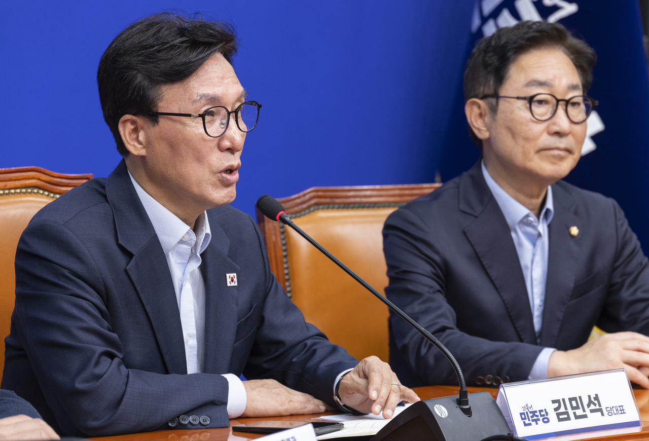 Democratic Party of Korea leader Kim Min-seok (left) speaks at the first meeting of the Grand Unity Promotion Committee at the National Assembly on Tuesday. [Yonhap]