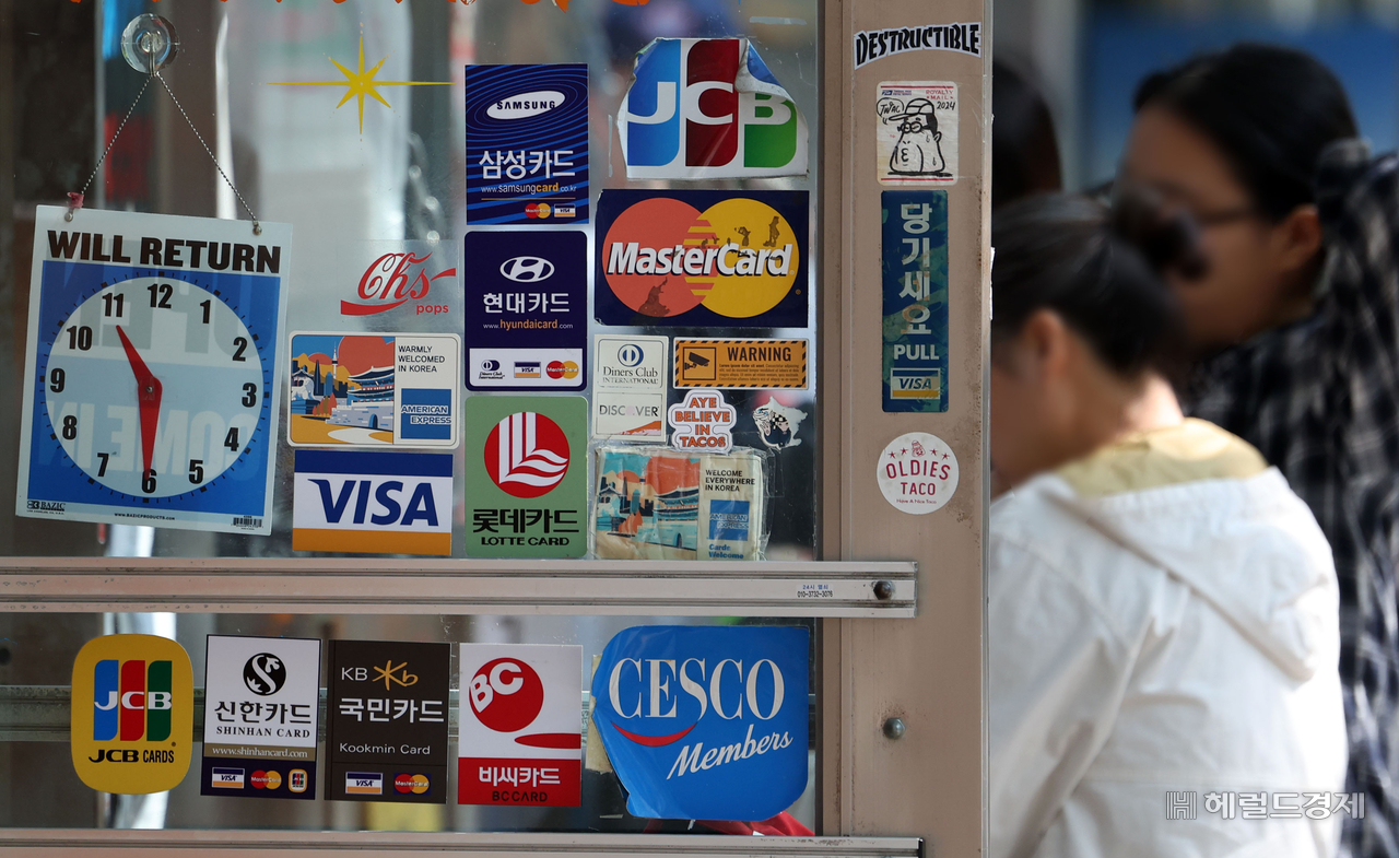 Stickers showing accepted credit cards are displayed at the entrance of a restaurant in Seoul. [Newsis]