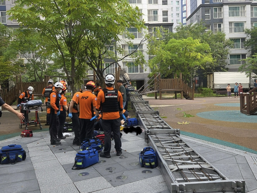 A moving ladder truck lies on its side following an accident at an apartment complex in Dongnam-gu, Cheonan, South Chungcheong Province, Wednesday. (Chungcheongnam-do Fire Headquarters)