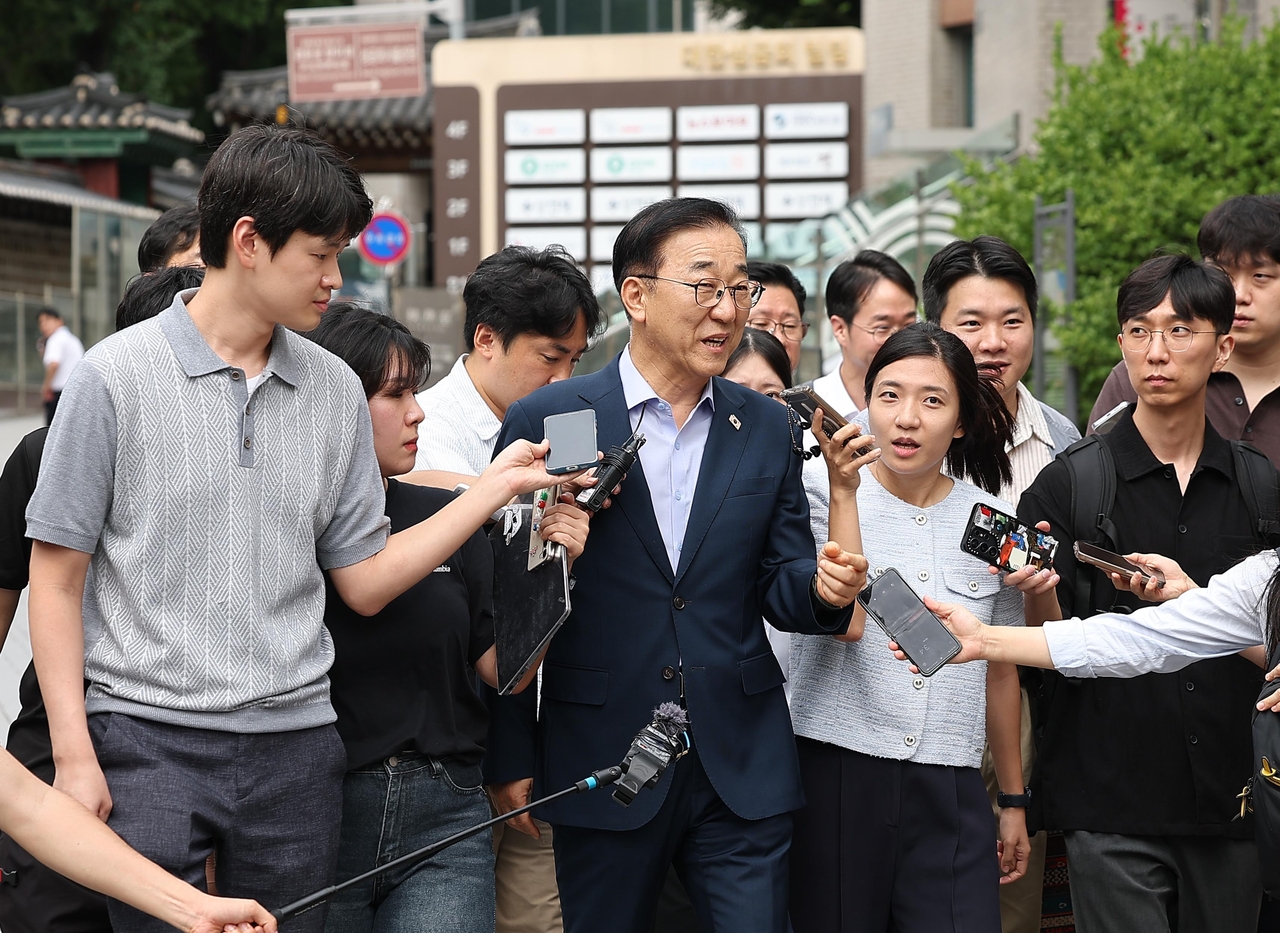 Land Minister Kim Yun-duk (C) fields questions by reporters ahead of his meeting with Seoul Mayor Oh Se-hoon in the capital city on Wednesday. (Yonhap)