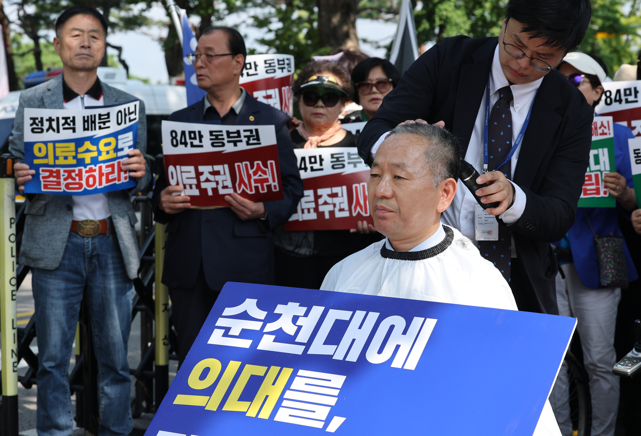 18일 서울 청와대 사랑채 앞에서 순천대 의대·대학병원 설립 전남광주동부권 범시민추진위원회가 개최한 궐기대회에서 더불어민주당 김문수 의원이  순천대에 의과대학과 대학병원을 함께 설립할 것을 촉구하는 삭발을 하고 있다. <연합뉴스>