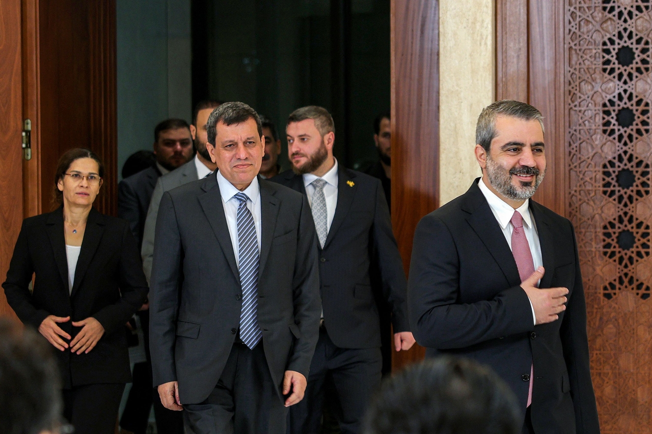 Mazloum Abdi (center), leader of the Kurdish-led Syrian Democratic Forces, arrives with Syria's interim foreign minister Asaad Shaibani (right) before a televised speech at the People's Palace in Damascus, Tuesday.    (AFP-Yonhap)